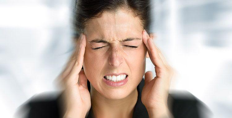 Una mujer sufriendo molestias del ruido en el lugar de trabajo